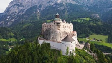 Hohenwerfen Şatosu Salzach Vadisi 'ndeki kayalık bir tepenin tepesinde, arka planda Berchtesgaden Alpleri ile çevrili, yemyeşil ormanlar ve yuvarlanan tepelerle çevrili..