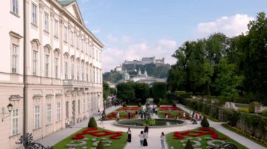 Avusturya 'nın Salzburg kentindeki Mirabell Sarayı ve Bahçeleri' nde, arka planda Hohensalzburg Kalesi 'nin bulunduğu canlı çiçek yatakları ve bir çeşme bulunuyor..