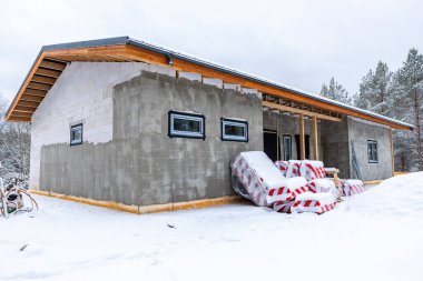 Tek katlı beton bir bina. İnşaat halinde eğimli bir çatı. Etrafı karla kaplı ve soğuk bir çevrede ağaçlarla çevrili..