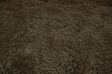 İnce parçacıkların oluşturduğu koyu tanecikli yüzeyin detaylı bir görüntüsü. İnce tümsekler ve depresifler, doğal dokuyu ve derinliği vurguluyor..