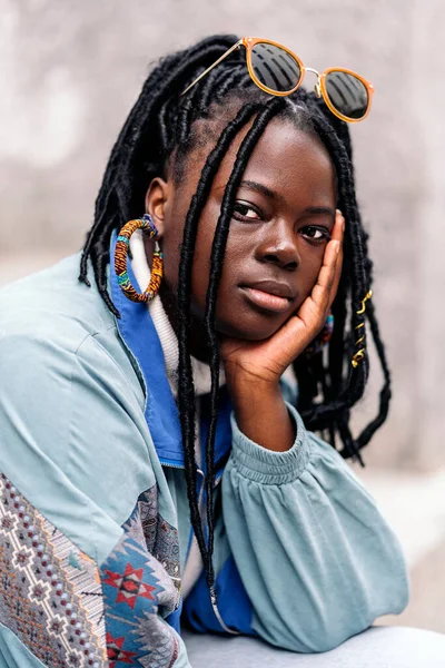 stock image Beautiful young african woman looking at camera outdoors and posing. She has cool braids.