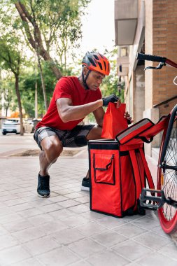 Afrikalı kurye varış yerine teslimat için paketi hazırlıyor..