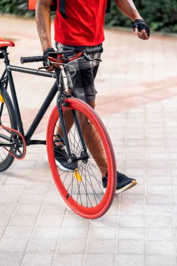 Şehirde havalı bisikletiyle dolaşan tanınmamış Afrikalı teslimatçı..