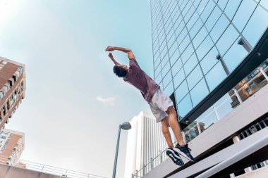 Tanınmayan genç adam şehirde parkur numaraları yapıyor ve eğleniyor..