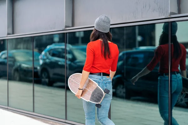 Αναγνωρίσιμη Κοπέλα Σκέιτερ Που Φοράει Καπέλο Περπατώντας Στο Δρόμο Και — Φωτογραφία Αρχείου