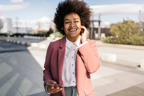 アフリカ系アメリカ人のビジネス女性が携帯電話を屋外で使用してエレガントな服を着て — ストック写真