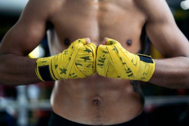 Sarı bandajlı genç, kaslı Latin boksör. Kickboks kavramı.