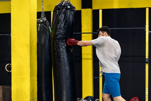 Kickboxing Fighter Wykonuje Ciosy Worku Treningowym Siłowni Pojęcie Kickboxing — Zdjęcie stockowe