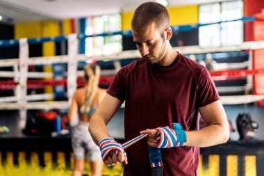 Spor salonunda klonlanmış boks şalıyla el ele tutuşan yetişkin bir adam. Eğitim kavramı.