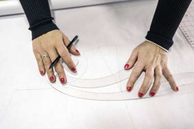 Moda atölyesinde çalışan tanınmamış bir terzi. Bir sonraki elbisesi için bir tasarım yapıyor..