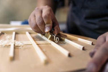 Tanınmayan luthier bir gitar yaratıyor ve geleneksel bir atölyede araçlar kullanıyor.