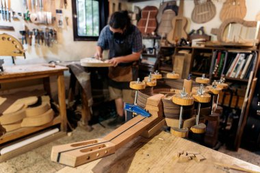 Luthier, Covid19 'dan dolayı maske takıyor gitar yapıyor ve atölyesinde çalışıyor..