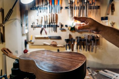 Tanınmayan Luthier atölyesinde gitar yapıyor ve aletler kullanıyor..