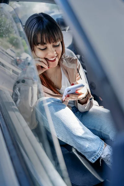 Mujer Feliz Sentada Coche Usando Teléfono Móvil Ella Está Usando — Foto de Stock