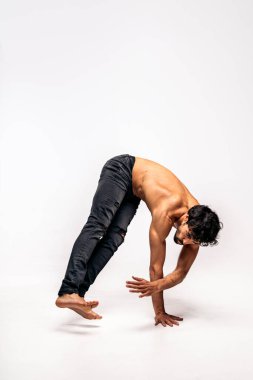 Stüdyoda beyaz arka planda dans eden çalışkan bir dansçı. Üstü çıplak..