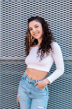 Güzel elbiseli, gülümseyen ve dışarıdaki kameraya bakan genç bir kadın..