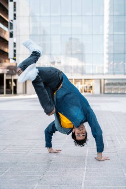 Yetenekli genç adam sokakta dans edip break dans yapıyor..