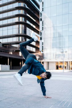 Sokakta pratik yapıp eğlenen havalı break dansçı. Dans ediyor ve kameraya bakıyor..