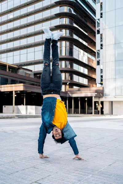 才能ある若いです男とともにカジュアル服をやってブレーク動きで通りに対する大規模な近代的な建物で街 — ストック写真