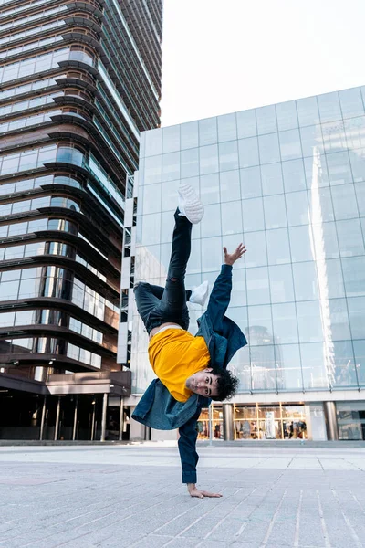 才能ある若いです男とともにカジュアル服をやってブレーク動きで通りに対する大規模な近代的な建物で街 — ストック写真