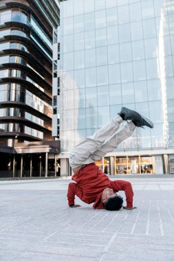 Yetenekli çocuk büyük modern binalara karşı sokakta break dans yapıyor..