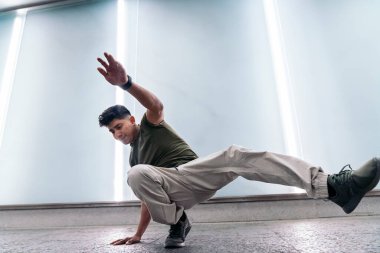 Yetenekli çocuk beyaz duvarın karşısında dans ediyor ve eğleniyor..