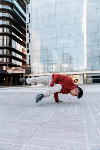 大規模な近代的な建物に対して街でブレイクダンスを練習才能の少年 — ストック写真