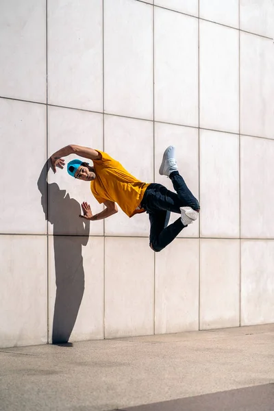 ストリートで白い壁に対してブレイクダンスをやっている若い男を自信を持って — ストック写真