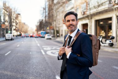 Şık takım elbiseli bir erkek girişimcinin portresi ve sabah işe giderken yolda yürürken bir paket içkiyle.