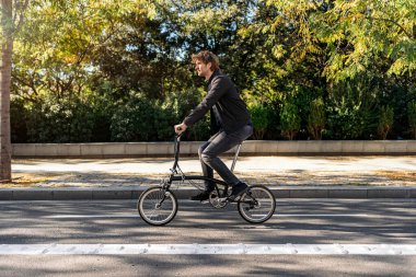 Stock photo of handsome man using his detachable bike during sunny day.
