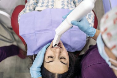 Stock photo of unrecognized female dentists wearing latex gloves examining a patient.