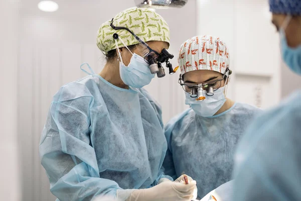 Zdjęcie Zespołu Kobiet Maskach Twarzy Okularach Powiększania Zębów Podczas Operacji — Zdjęcie stockowe