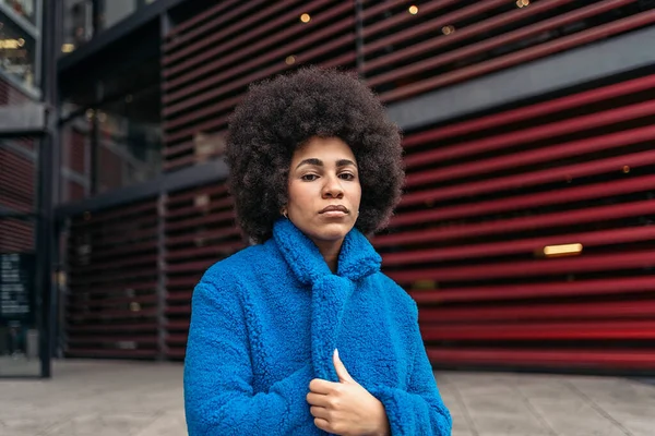 Stock Photo Expressive Afro Woman Wearing Cool Blue Coat Looking — Fotografia de Stock