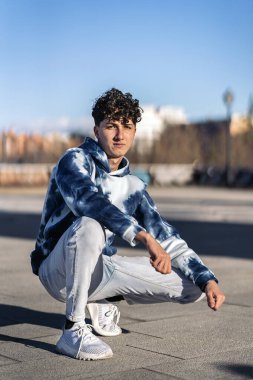 Stock photo of serious boy wearing urban clothes posing and looking at camera.