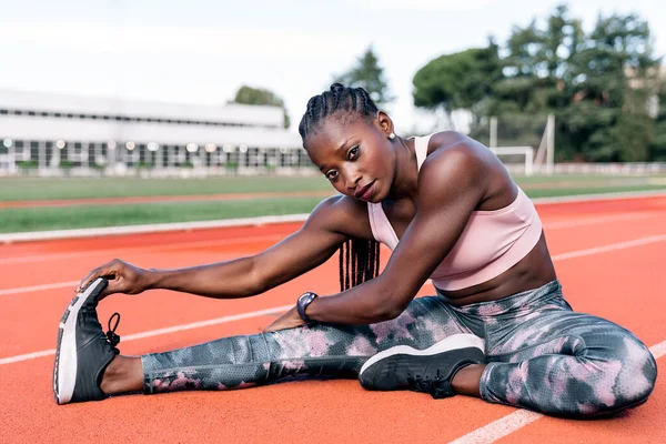 トレーニング前に足を伸ばすアフリカ系アメリカ人の短パンの写真 — ストック写真