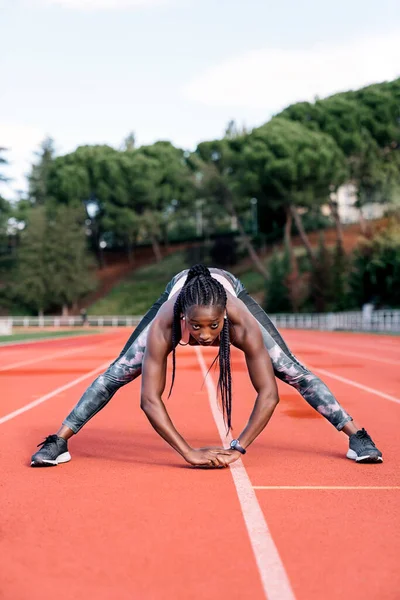 Photo Stock Une Sprinteuse Afro Américaine Étirant Ses Jambes Avant — Photo
