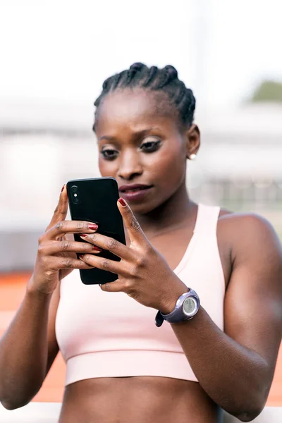 携帯電話を使ってアフリカ系アメリカ人のスプリンターの写真 — ストック写真