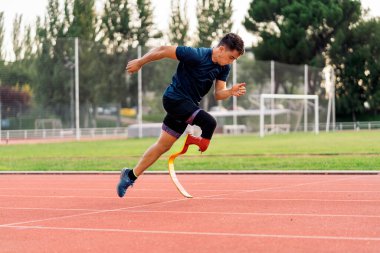 Koşu bandında bacak protezi olan genç sporcu eğitimlerinin stok fotoğrafı.