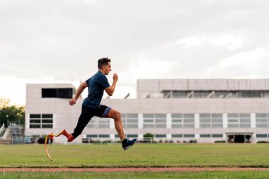 Koşu bandında bacak protezi olan genç sporcu eğitimlerinin stok fotoğrafı.
