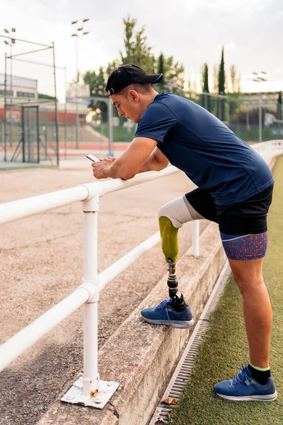 Disabled Man Athlete Using His Phone While Doing Break Stock Photo