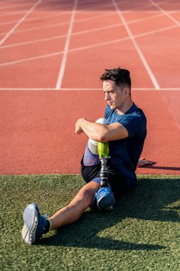 Engelli adam atlet bacak protezi ile germe. Paralimpik spor kavramı.