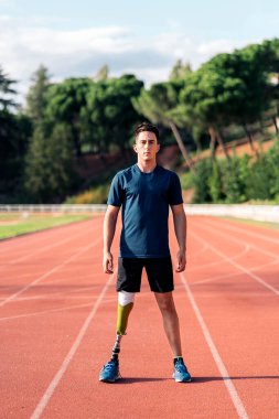 Koşu pistinde kameraya bakan engelli bir sporcunun stok fotoğrafı..