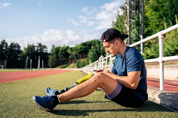 Disabled Man Athlete Using His Phone While Sitting Grass — Foto de Stock