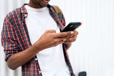 Şehirde eğlenen ve cep telefonunu kullanan tanınmamış Afrikalı çocuğun stok fotoğrafı..