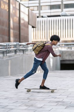 Şehirde paten kayan Afro çocuğun stok fotoğrafı..