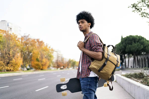 Foto Saham Seorang Pemuda Afro Berjalan Kota Dan Membawa Papan — Stok Foto