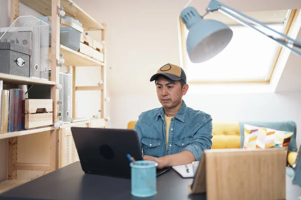 Porträt Eines Konzentrierten Asiatischen Mannes Mit Laptop Bei Der Arbeit lizenzfreie Stockfotos