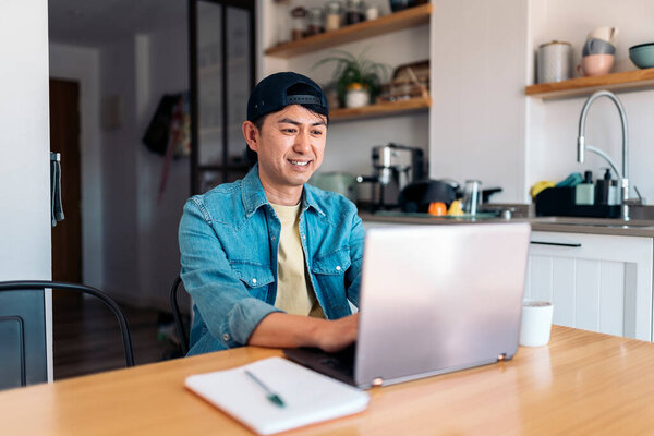 Cheerful Asian Casual Businessman Working Laptop Sitting Domestic Kitchen Home Stock Picture