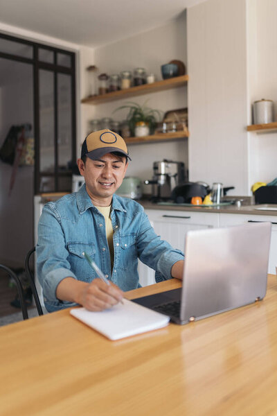 Vertical Photo Asian Casual Businessman Using Laptop While Writing Notes Royalty Free Stock Images
