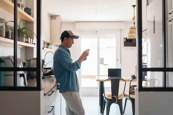 Casual Chinese Businessman Using Mobile Phone Standing Kitchen Next Home Royalty Free Stock Images